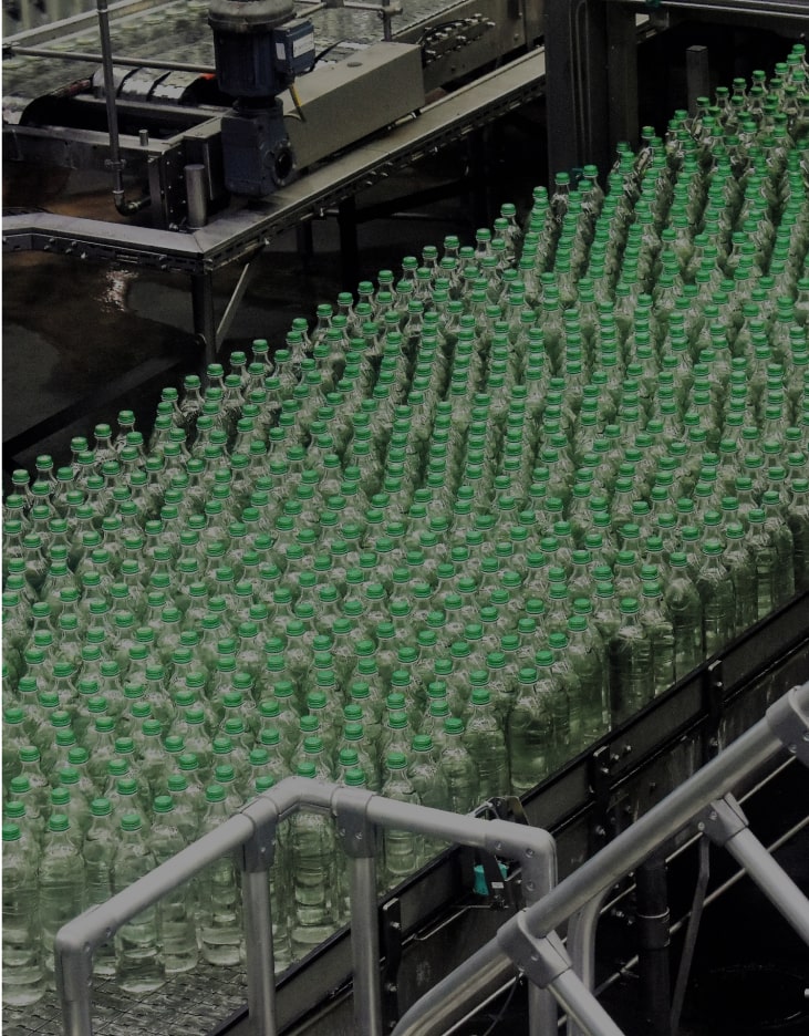 plastic bottles with green lids on a factory line