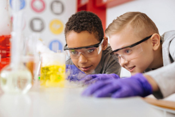 two kids looking at a science experiment in a beaker