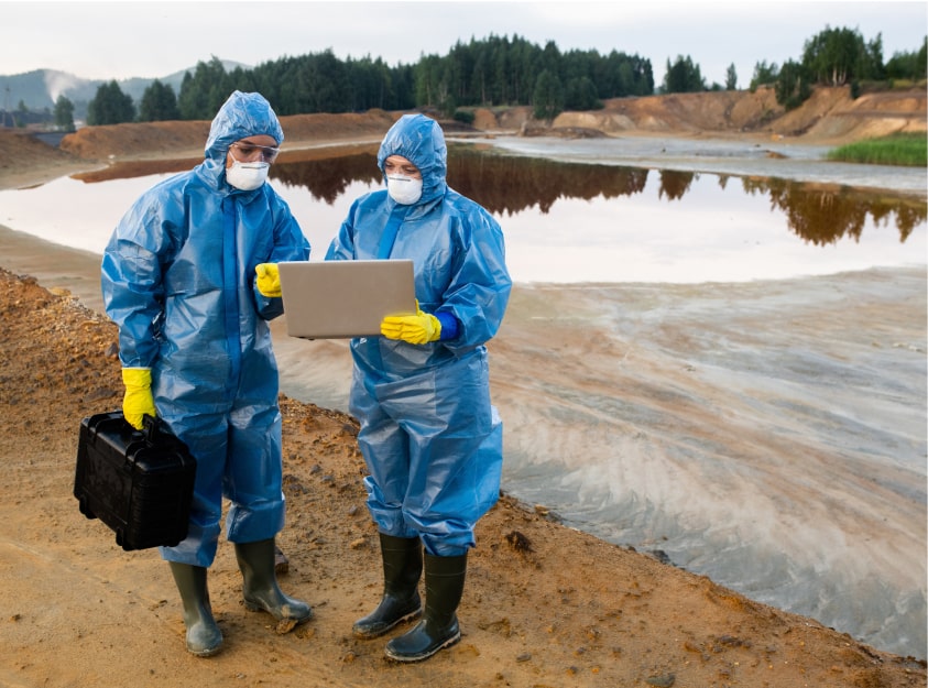 2 people in PPE out working at an industrial water testing site